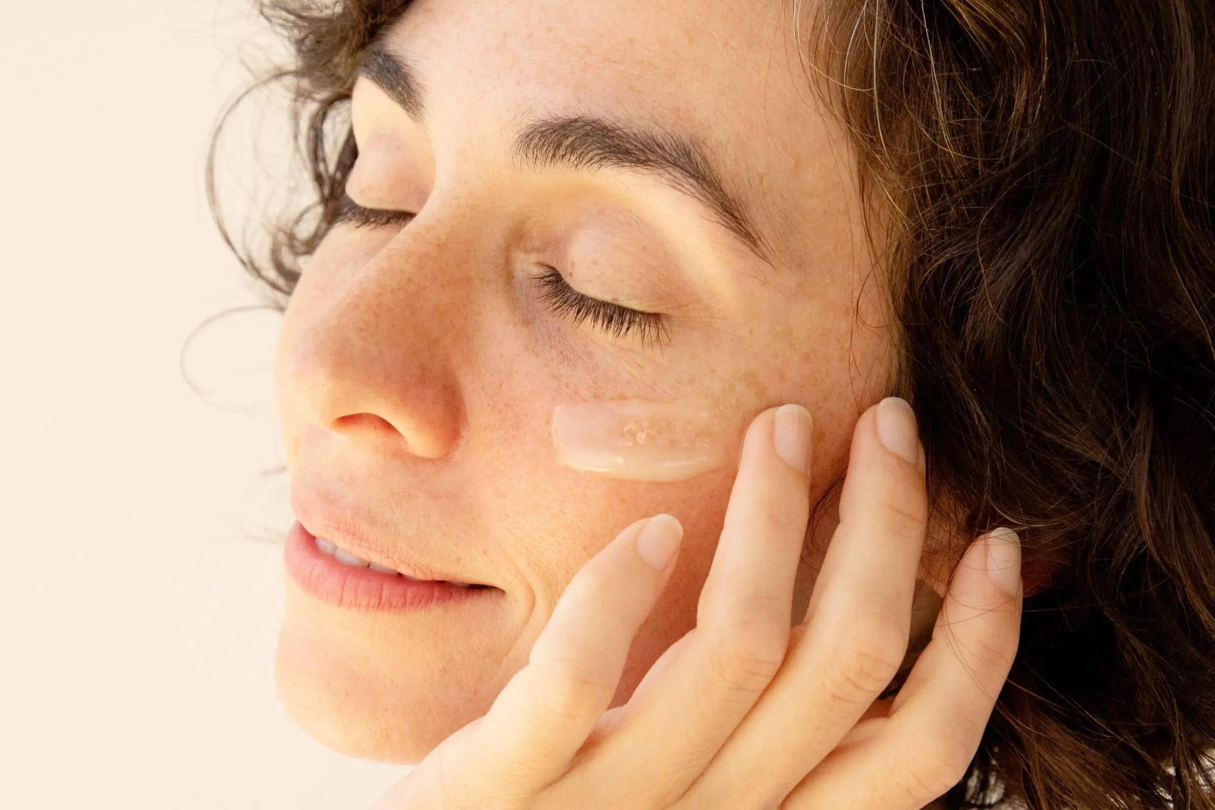 Woman using 100% PURE Retinol Restorative Balm 