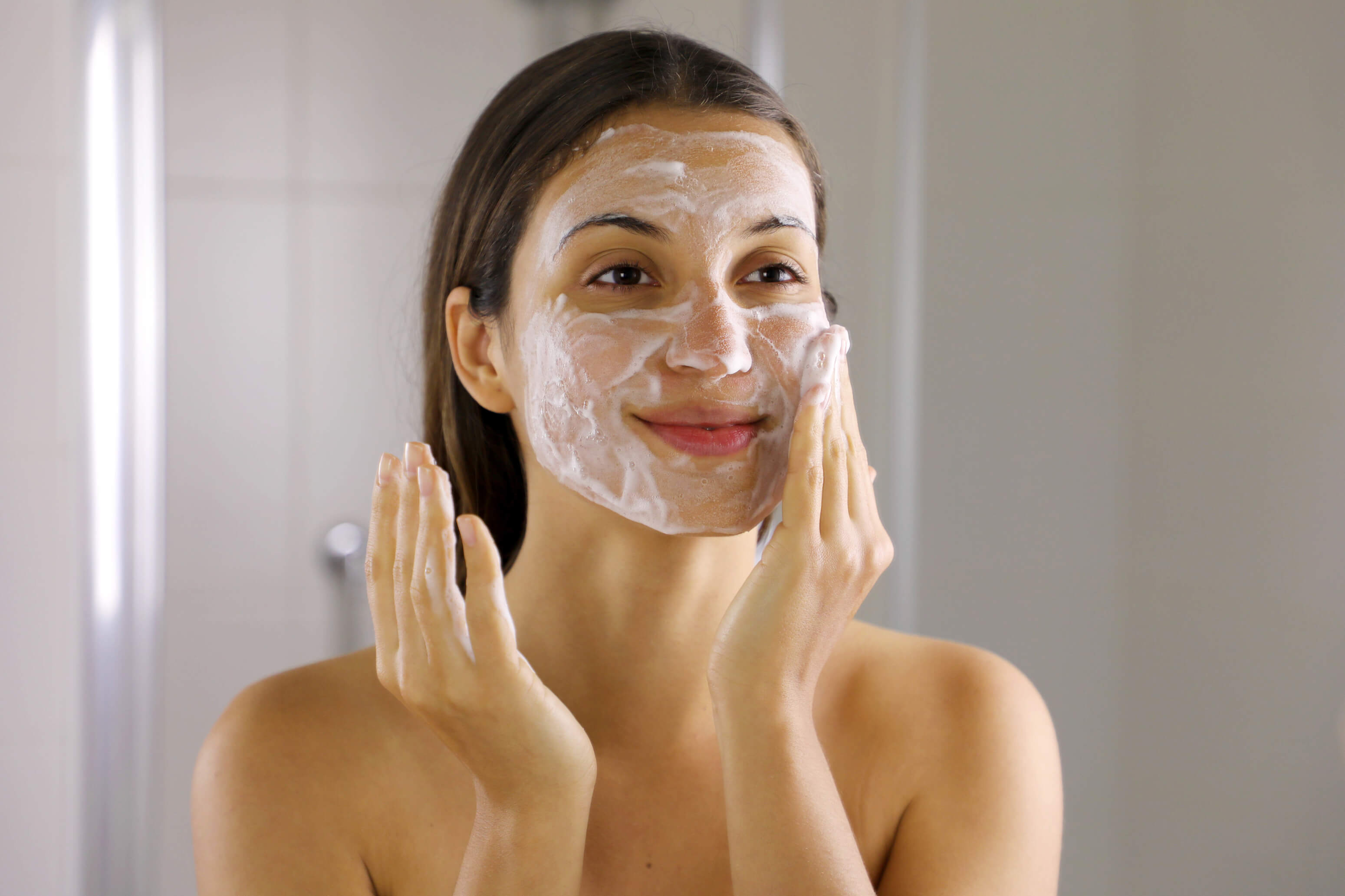 Woman washing her face with a foaming cleanser