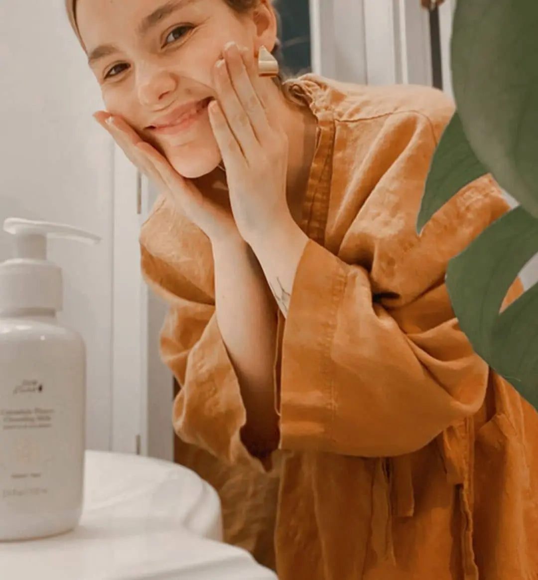 Woman washing her face with 100% pure calendula cleanser