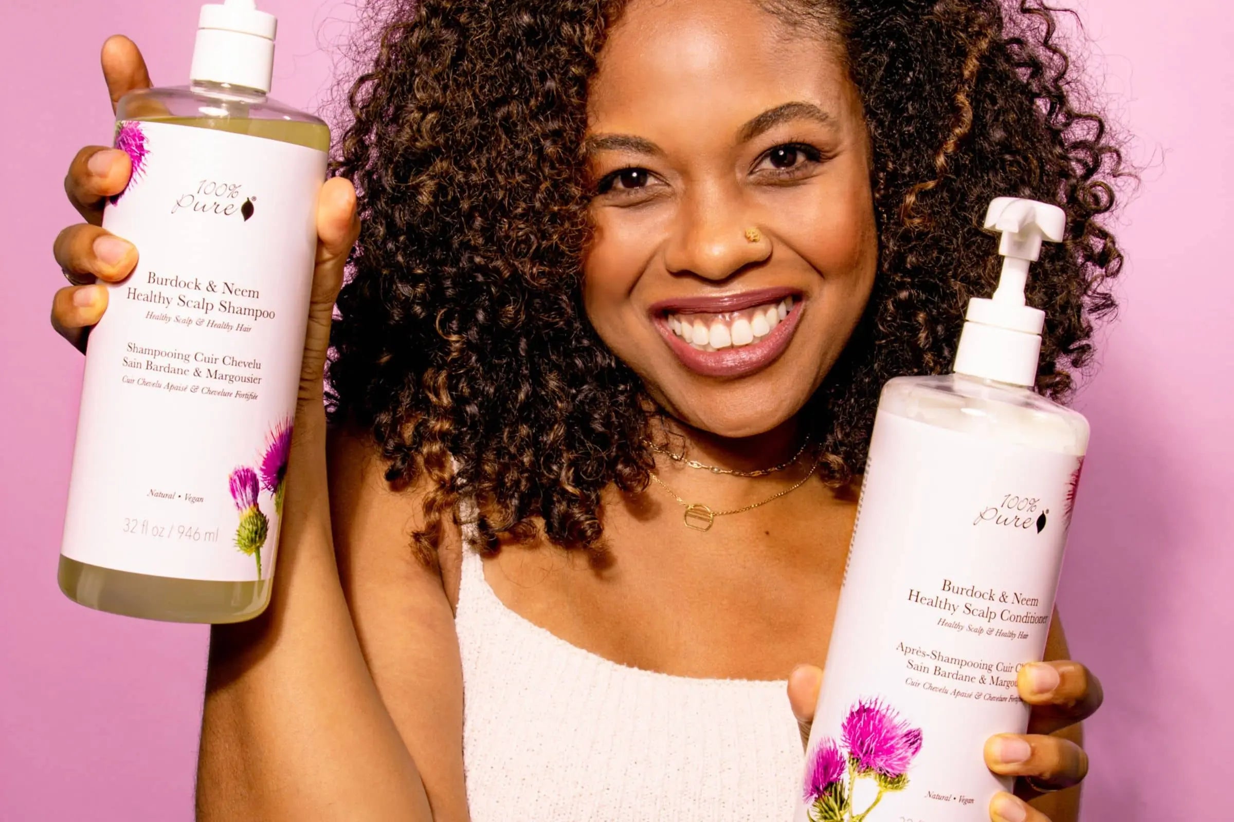 Model posing with 100% PURE Burdock and Neem Healthy Scalp Shampoo and Conditoner