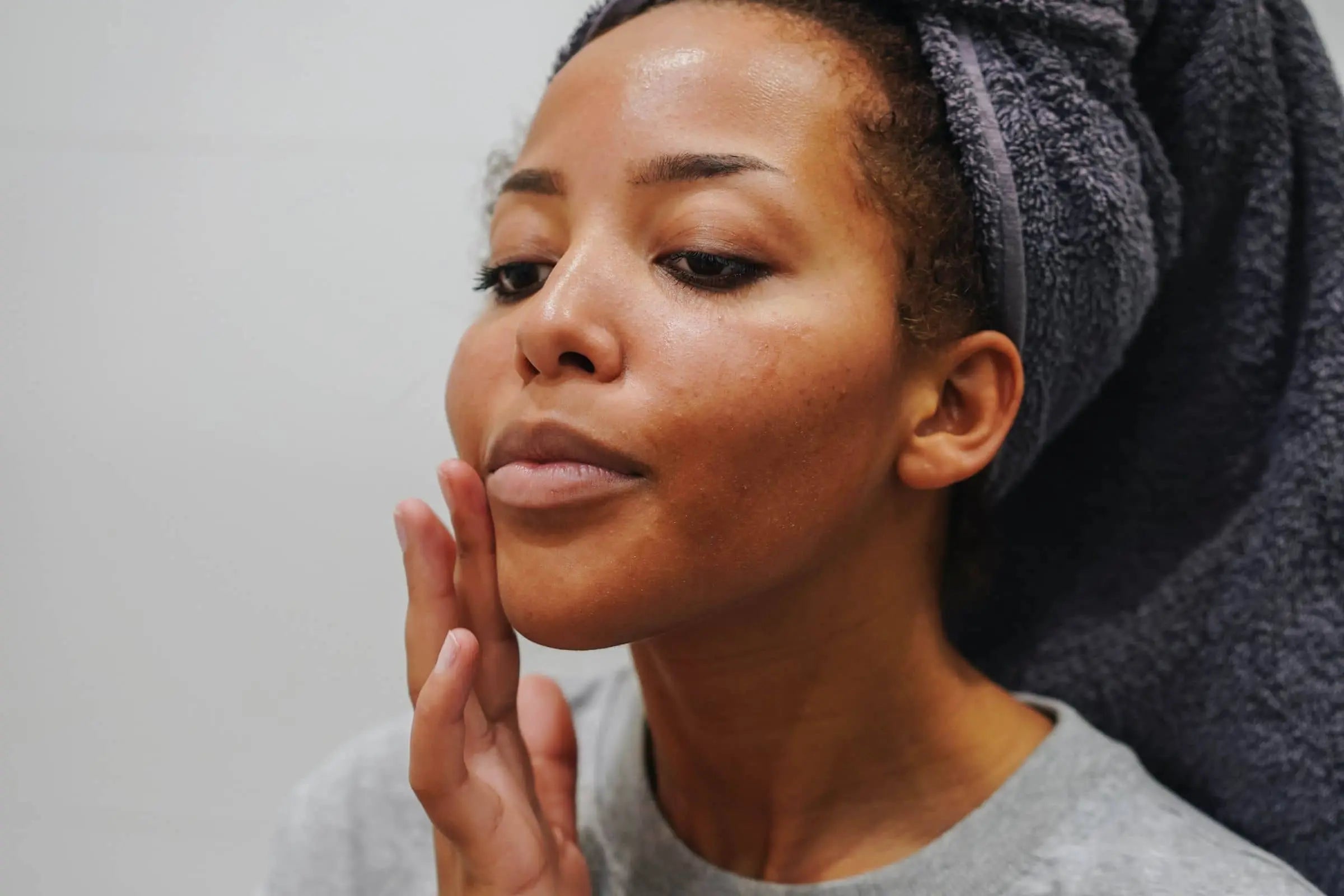 Woman inspecting her face before skincare layering