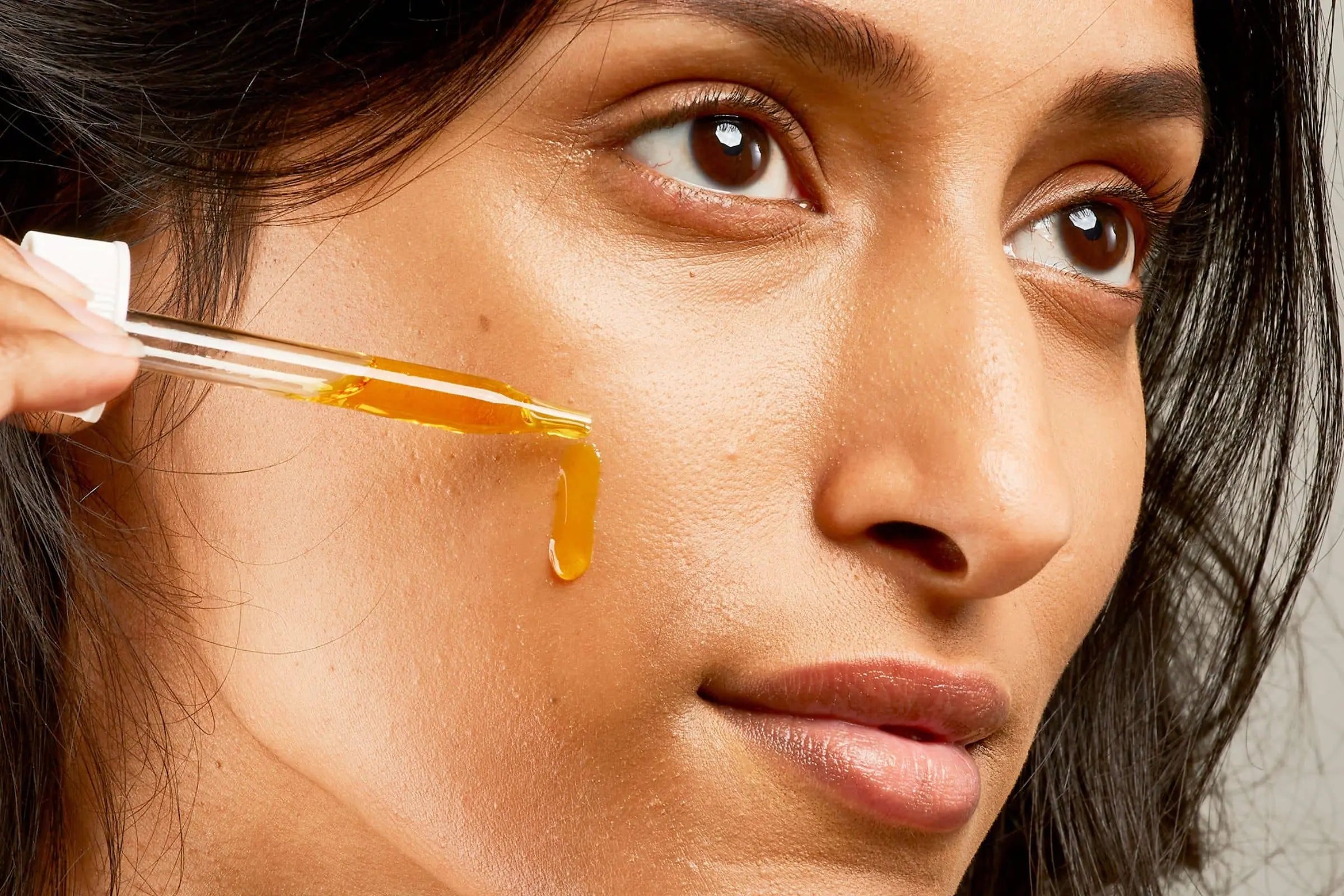 Woman using 100% PURE facial oil