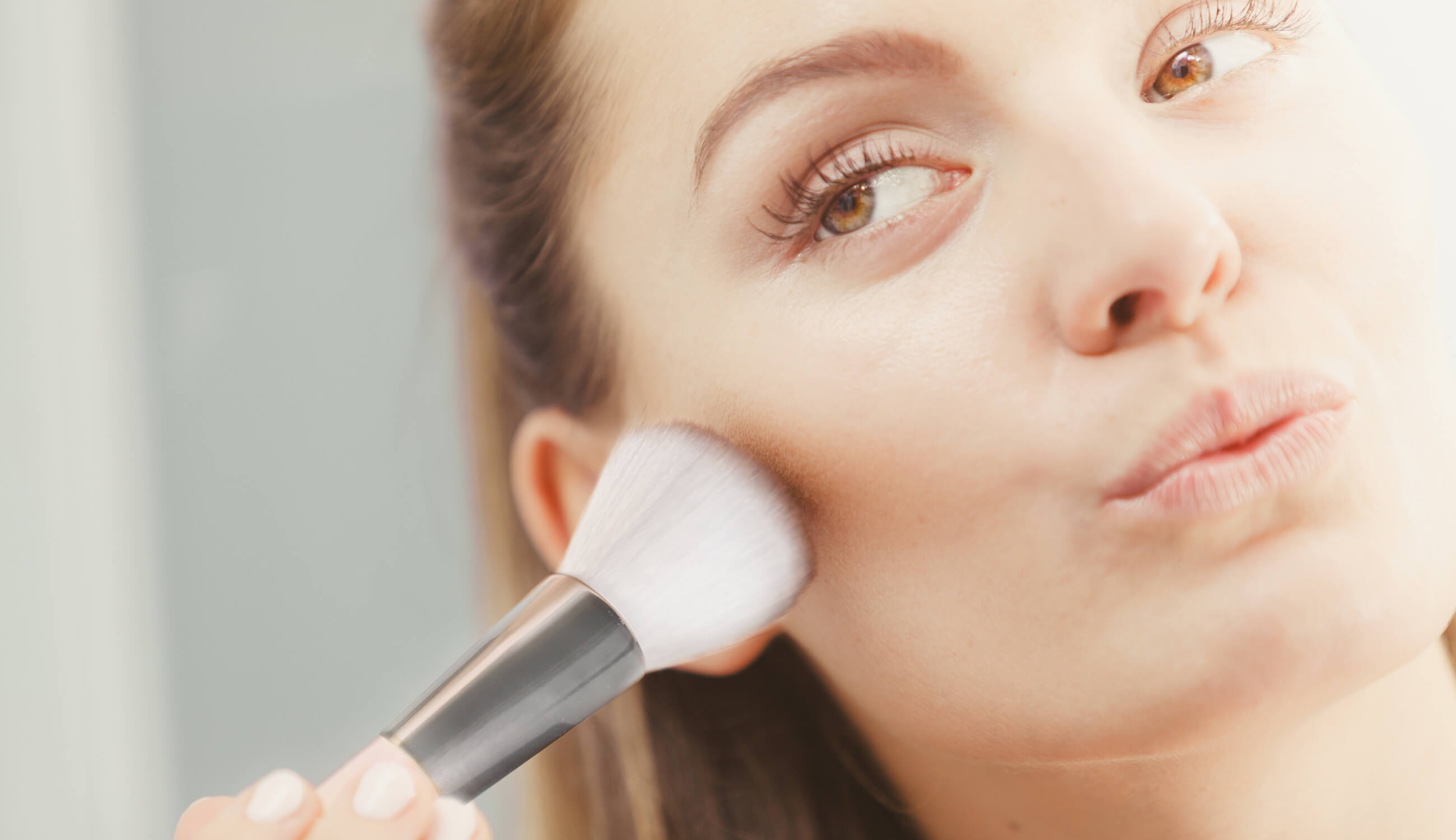 Woman applying makeup with makeup brush