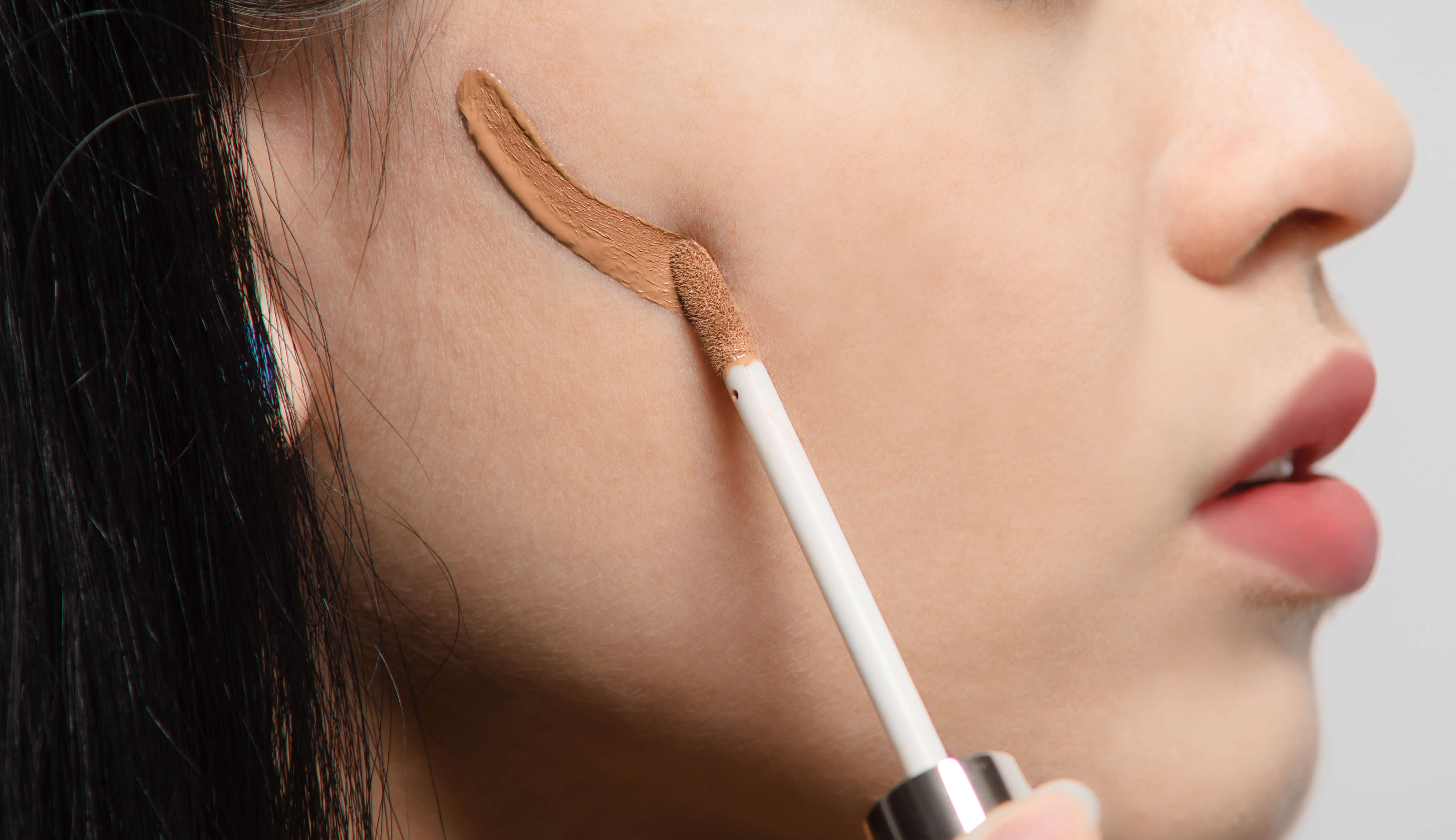 Woman applying 100% PURE Contour to cheek.